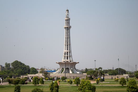 Stunning daytime capture of Minar-e-Pakistan surrounded by lush greenery in Lahore.