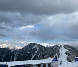 Winter snow scene at the picturesque Malam Jabba resort with dramatic clouds and snowy peaks.