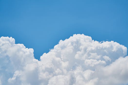 Vibrant image of fluffy white clouds against a clear blue sky, perfect for nature and weather themes.