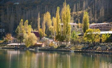 Beautiful autumn scene of Skardu with colorful trees, tranquil lake, and reflections.