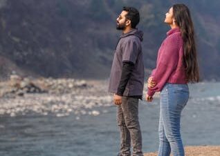 Couple on Naran honeymoon tour package walking through Shogran Siri Paye alpine meadows in summer
