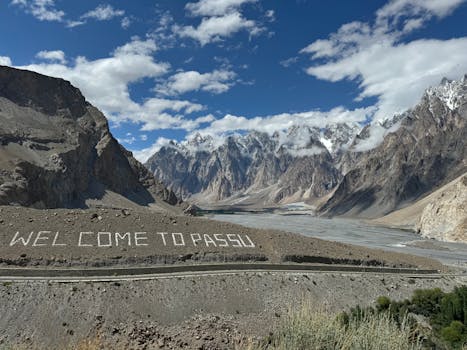 Breathtaking view of the Passu Cones with a welcoming sign, showcasing stunning mountainous landscape in Pakistan. pakistan-tour-packages