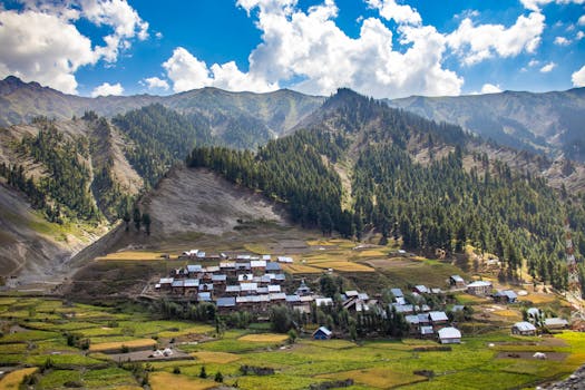 Panoramic view of Gurez village in Kashmir, surrounded by lush mountains and fields.