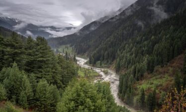 Neelum valley couple trip with turquoise river and mountain backdrop 2026