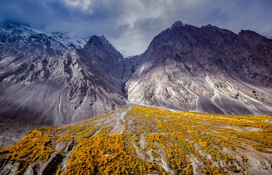 Stunning mountain view in Chitrāl, Pakistan showcasing dramatic peaks and autumn foliage.